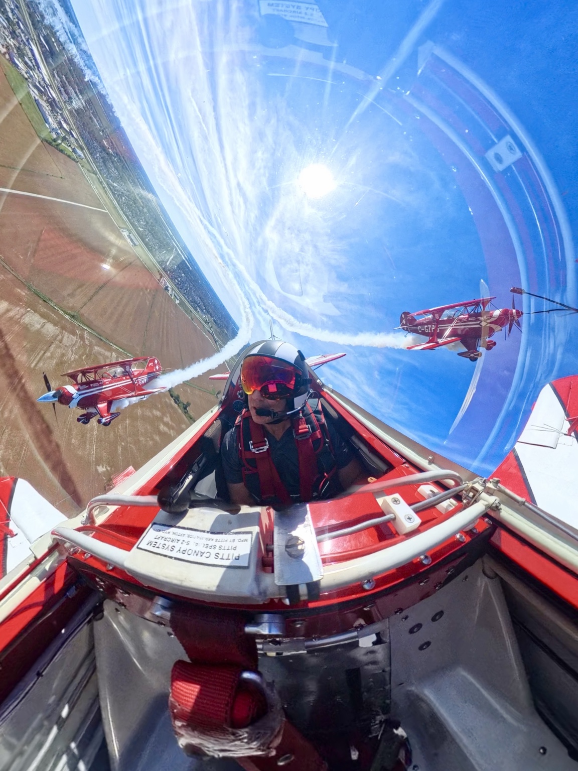 A Northern Stars pilot in the cockpit with red biplanes flying in formation